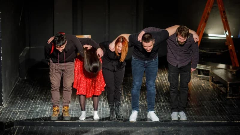 Improv actors taking a bow on stage after a performance at Bridge Improv Theater